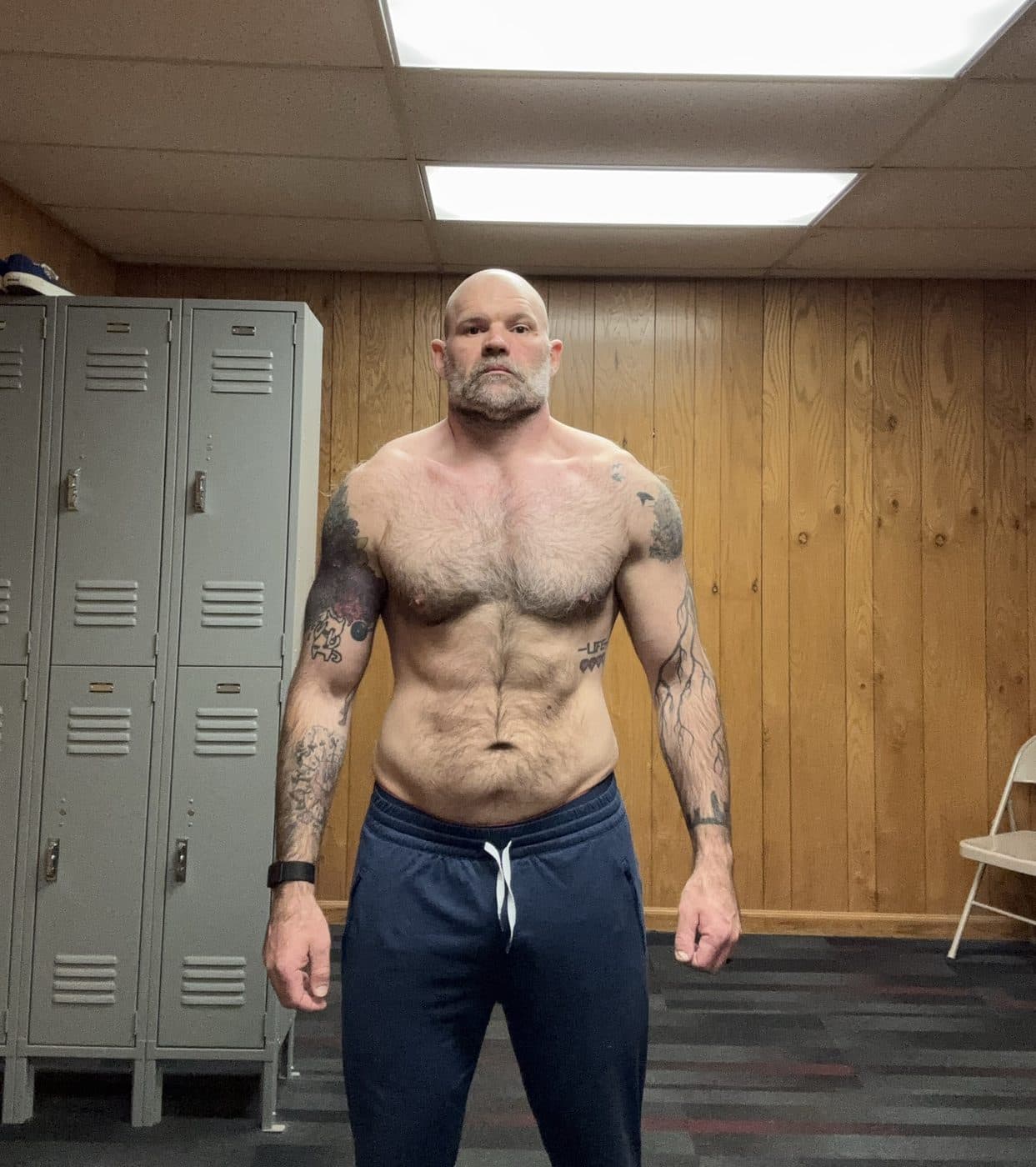 Front progress photo at 214 pounds in the same locker room, May 2026